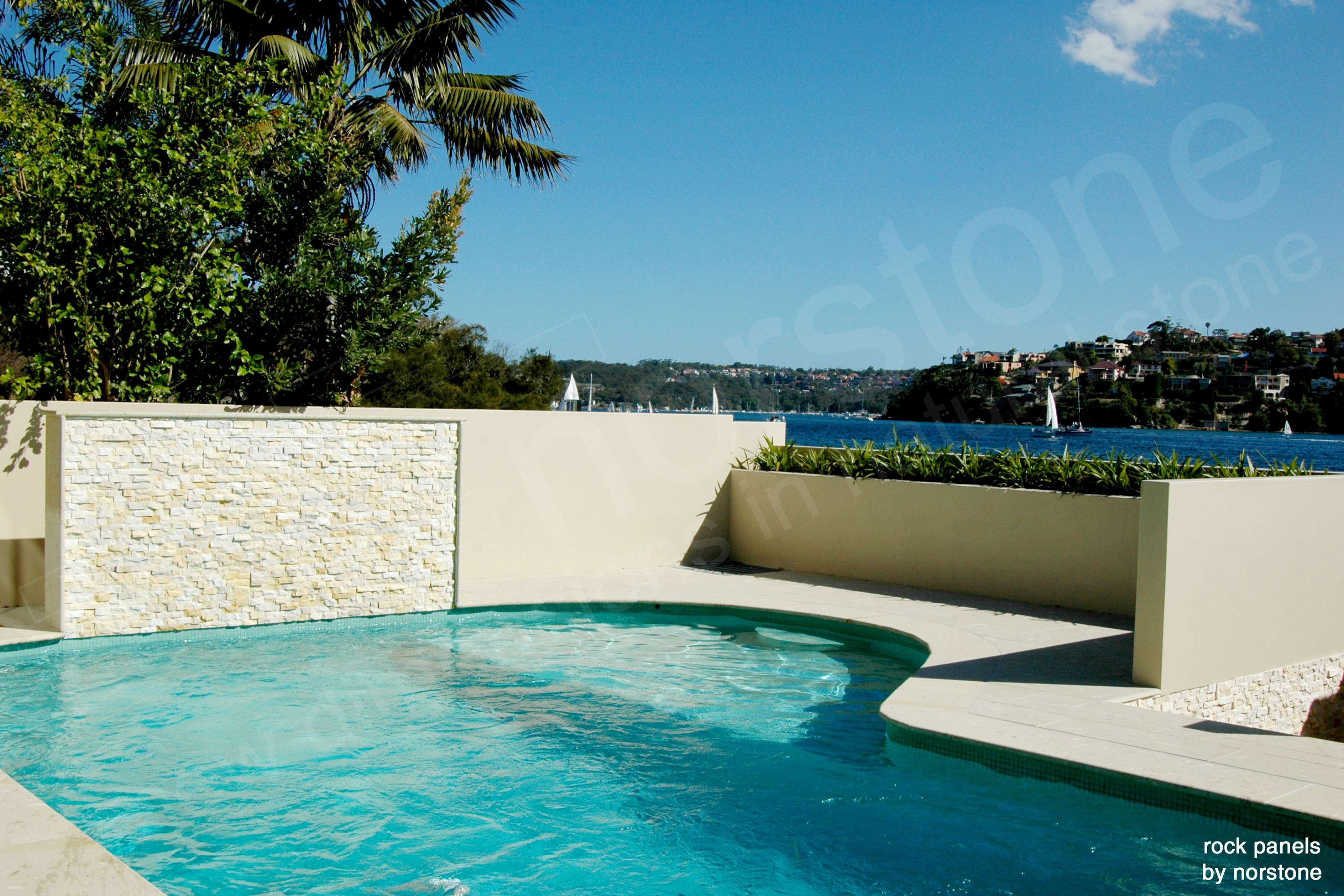 Home on the Coast of Australia featuring Norstone Ivory Rock Panels on a pool feature wall and sea wall